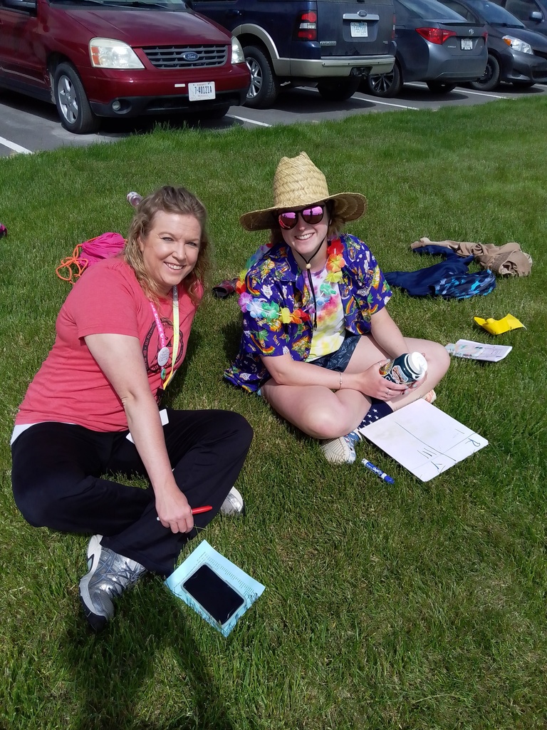 two teachers sitting on the grass